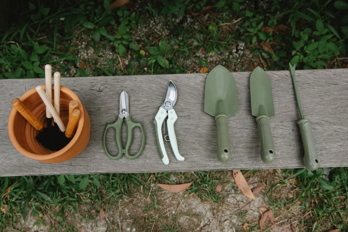Tijeras, palas y otras herramientas de jardín sobre un banco de madera
